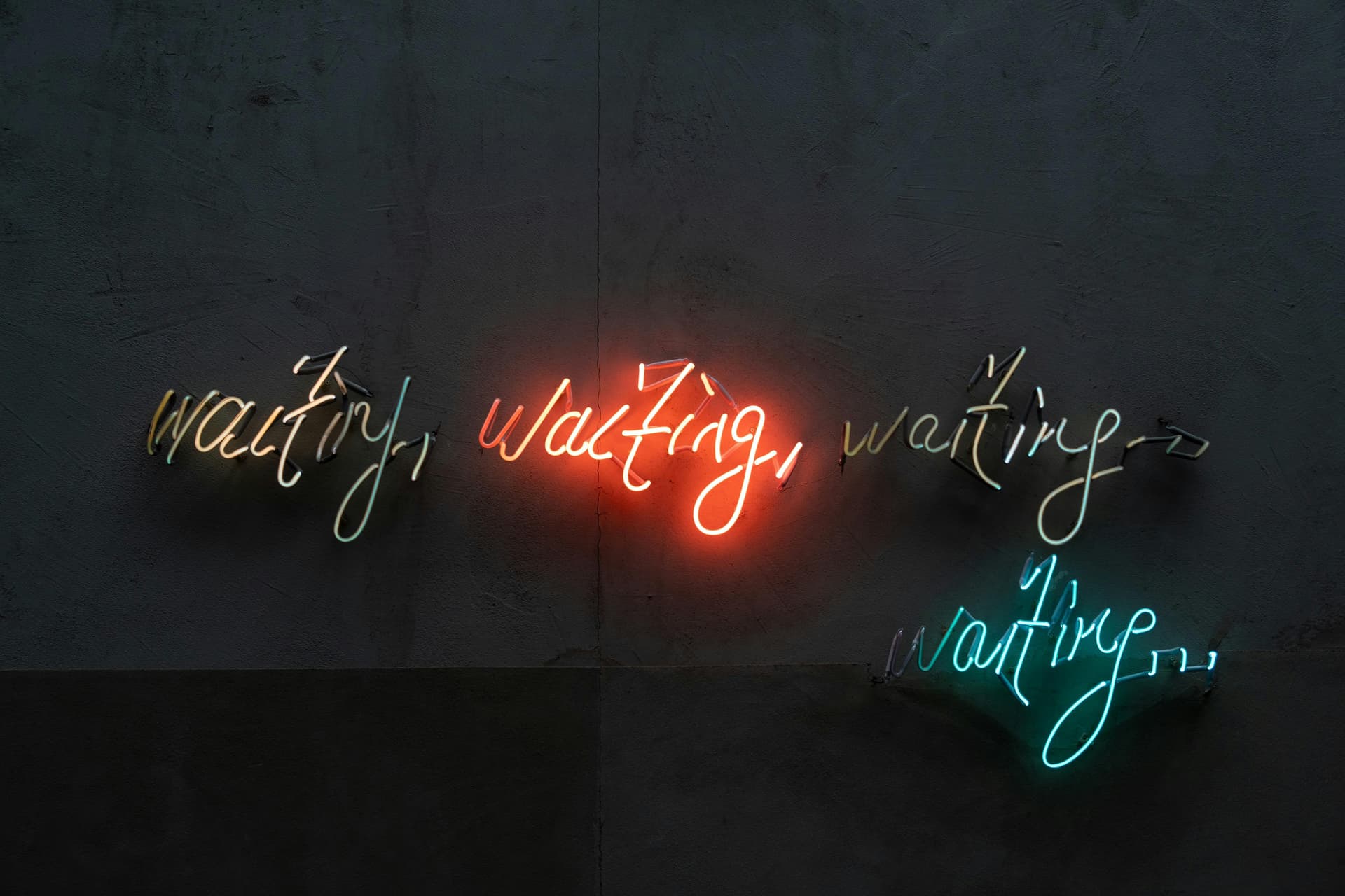 Neon signs that read "waiting, waiting, waiting, waiting..."