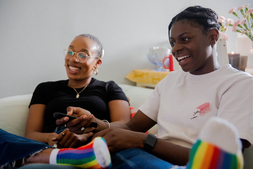 Two teens looking off to the side of the screen and smiling